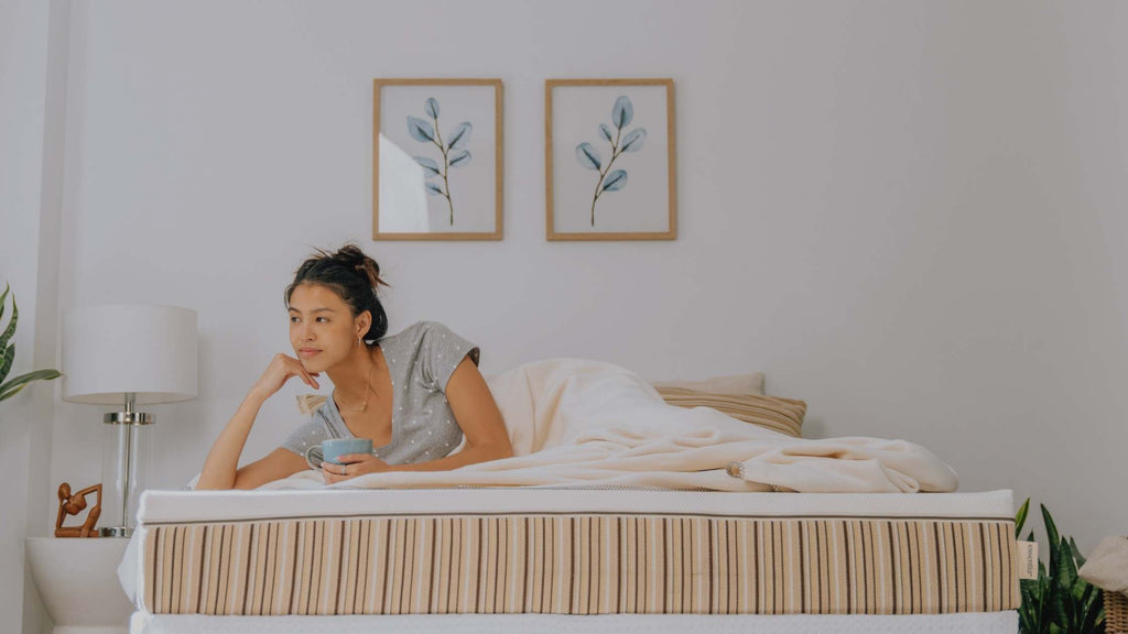 Beautiful woman smiling softly while sitting on an Essentia mattress
