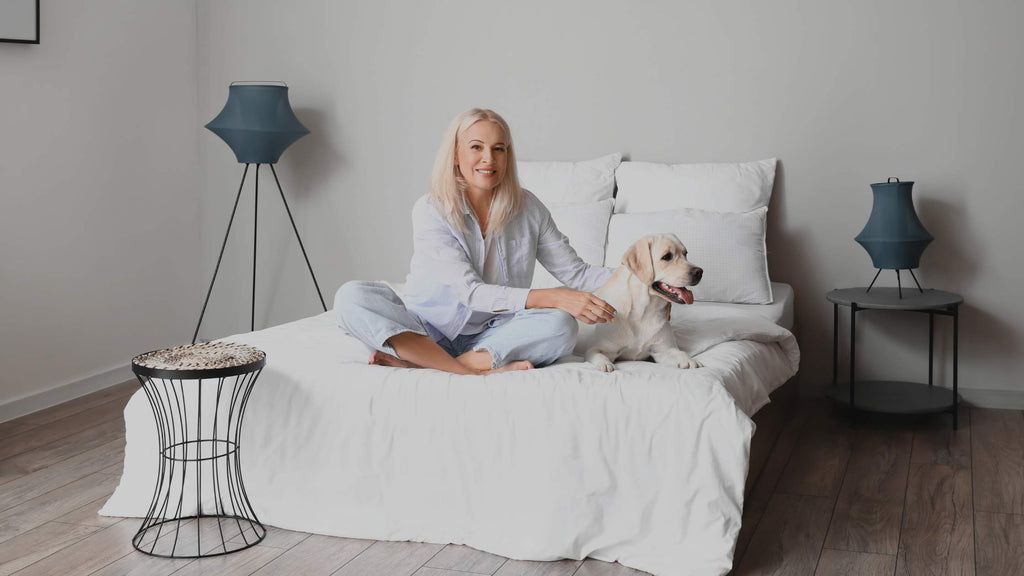 Woman relaxing in bed with her dog. 