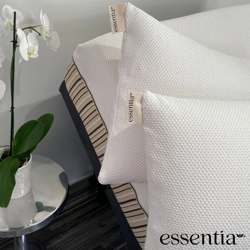 Essentia latex cloud pillows on a mattress with a white orchid on the side table