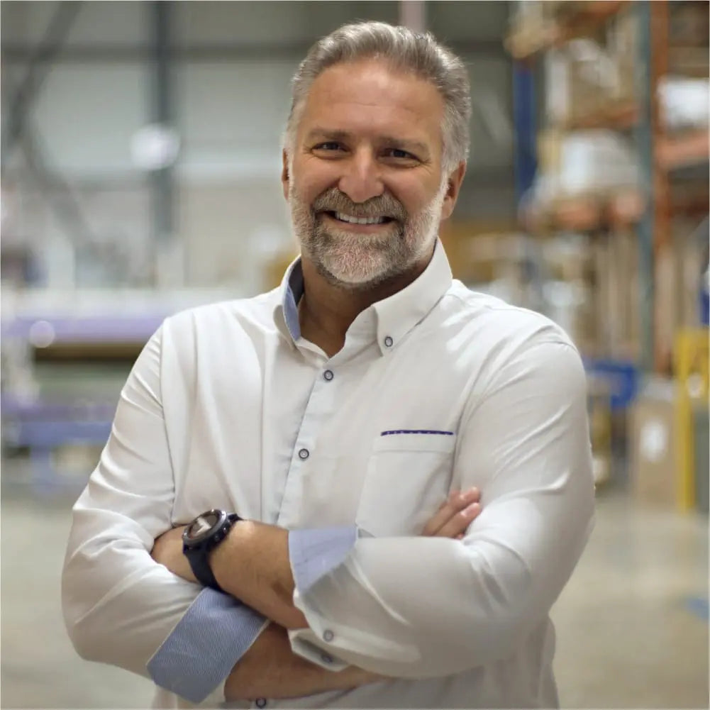 Jack Dell'Accio ceo and founder of Essentia stand with arms folded in the Essentia warehouse.