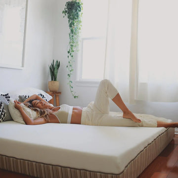 Woman laying down on the Essentia Stratami mattress the number one rated foam mattress