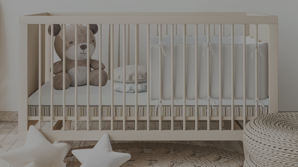 Essentia lala crib mattress shown in a crib with a teddy bear