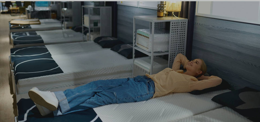 Woman testing memory foam mattresses looking for a Tempur mattress alternative.