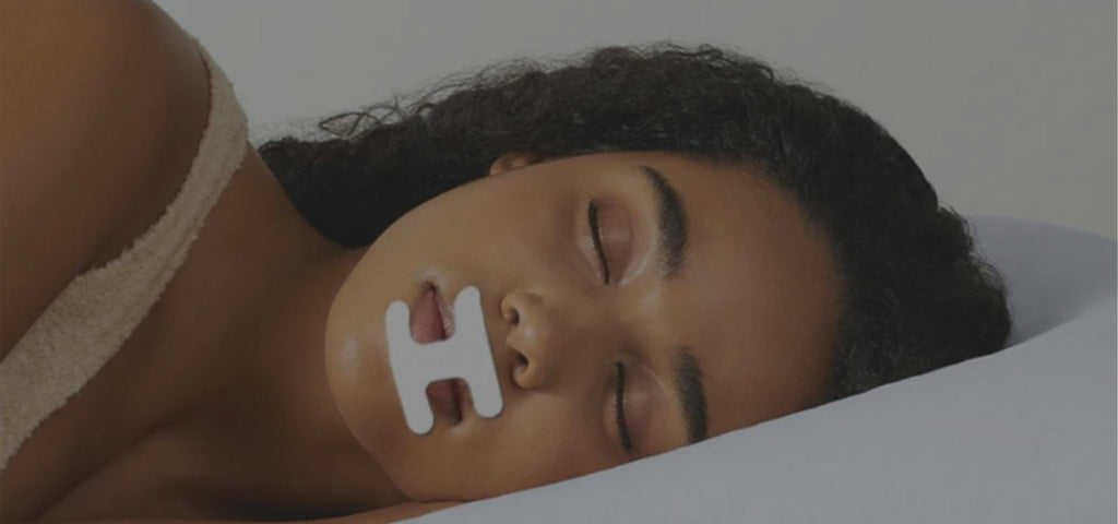 Woman lying on her side sleeping with mouth tape over her mouth to promote nasal breathing