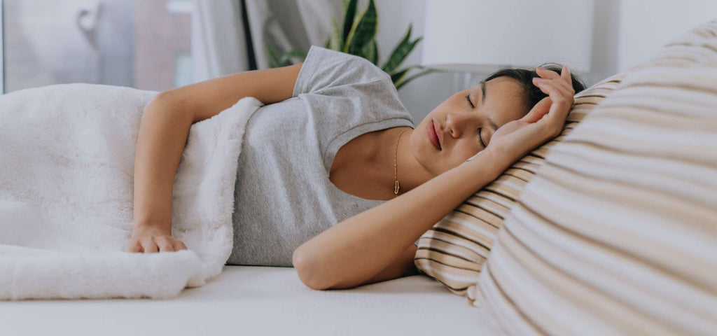 Woman sleeping peacefully on an Essentia organic mattress.