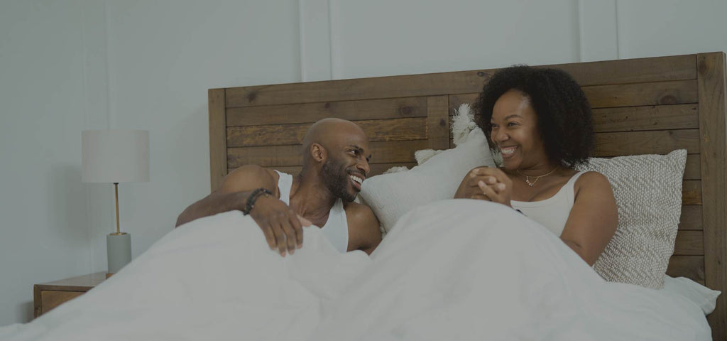 Happy couple relaxing on their Essentia organic mattress