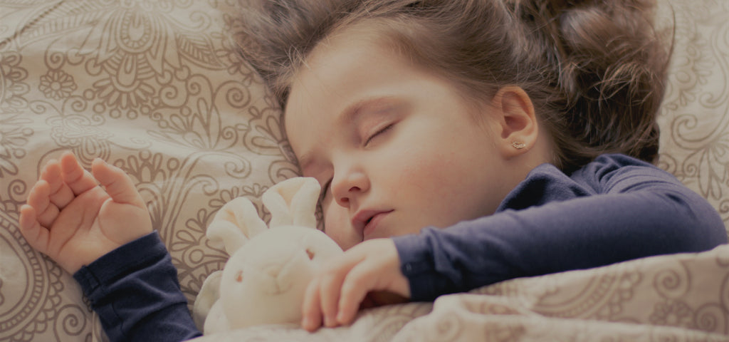 Child sleeping peacefully with her bunny