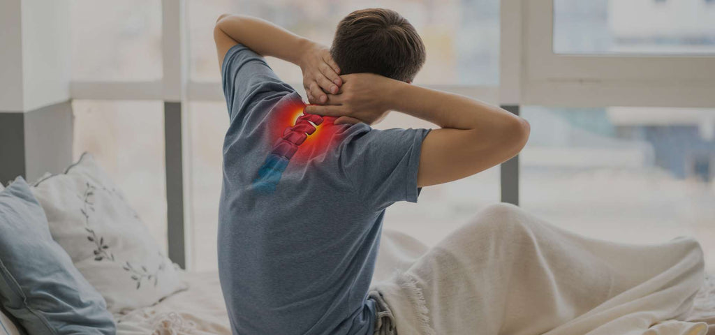 Man waking up grasping his neck in pain