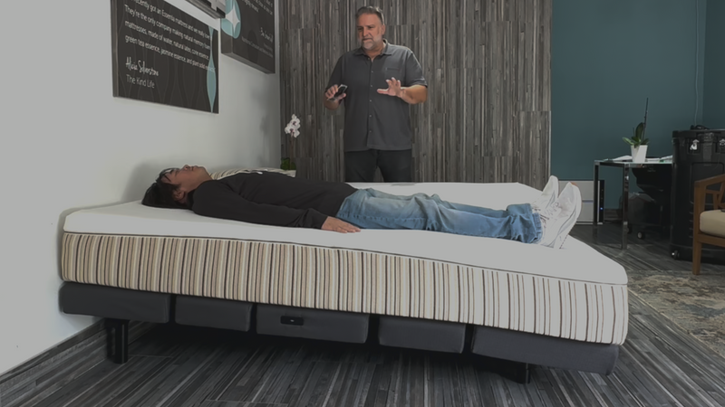 Image showing a man lying down on a mattress that is set to an incline