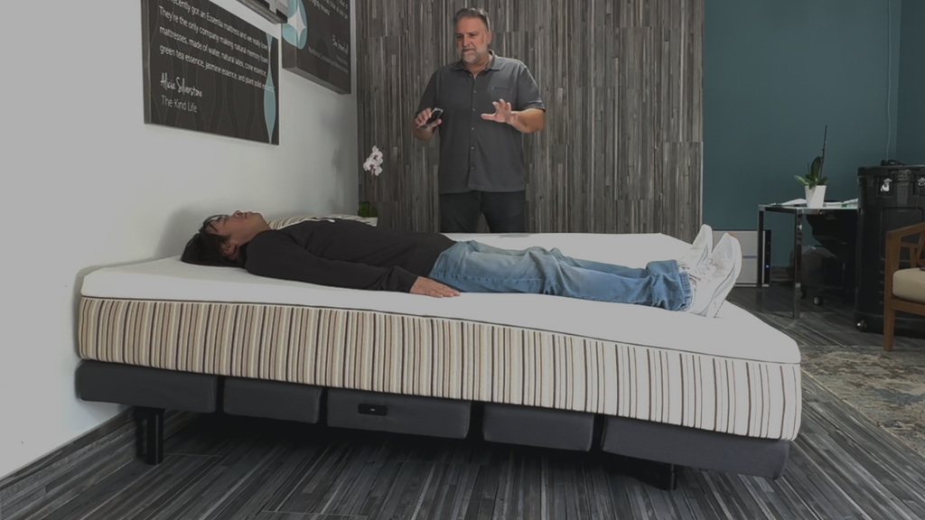 Image showing a man lying down on a mattress that is set to an incline