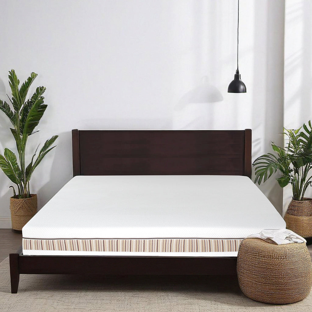 Essentia Venti Organic Latex Double Sided Mattress shown on a Mesa Wood Bed Frame in a clean white bedroom with a brown foot poof and two palm trees