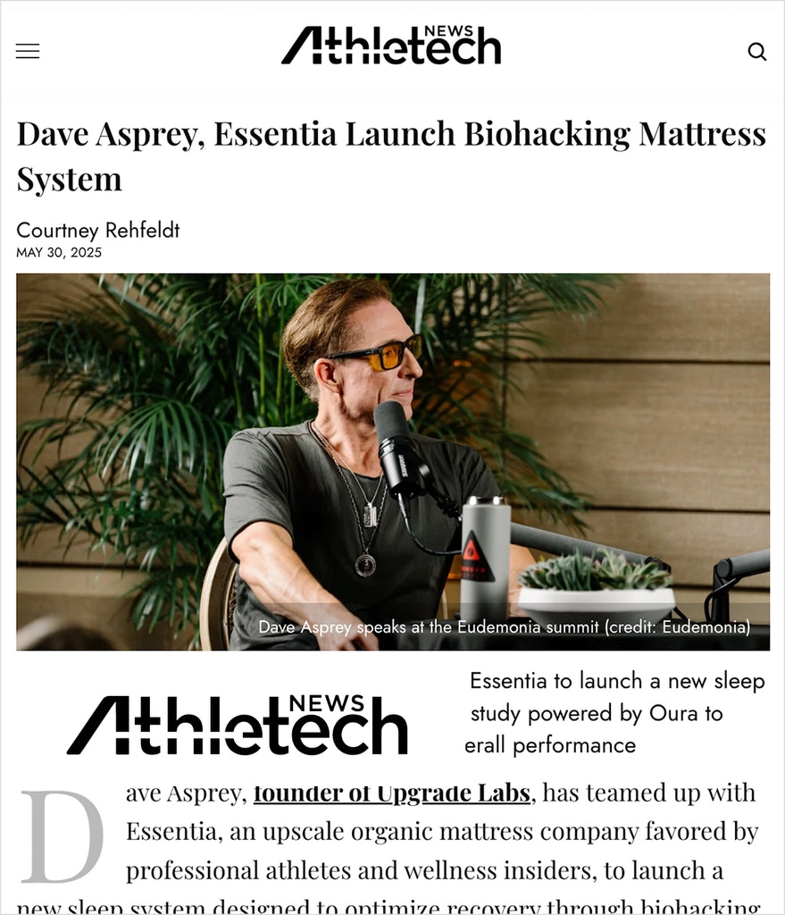 News article about Dave Asprey and Essentia launching a biohacking mattress system, featuring Dave Asprey speaking into a microphone.