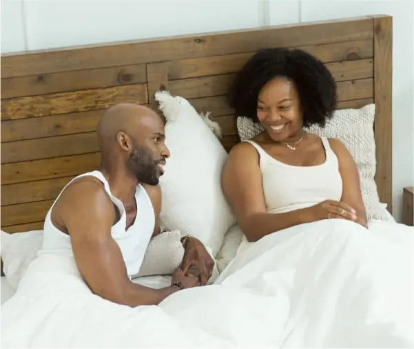 Smiling couple in bed enjoying their Essentia mattress
