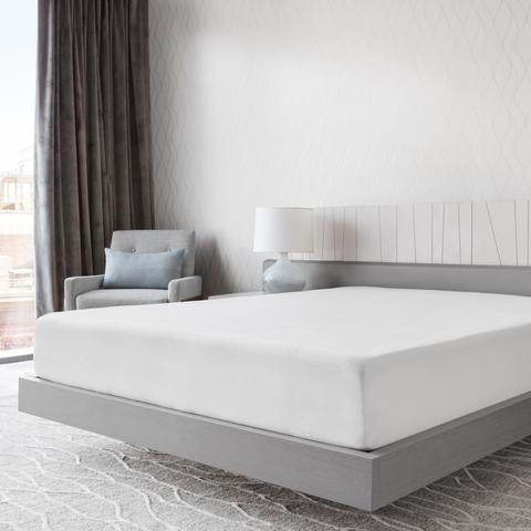 Stay Well Mattress by Essentia show in a hotel room covered with sheets