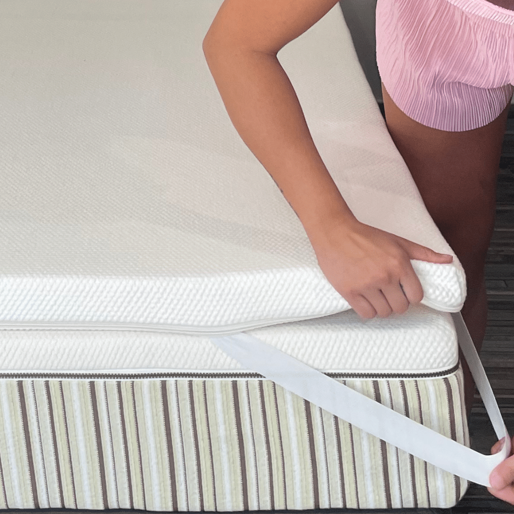 Girl putting Essentia Zero Gravity Organic Latex Topper on an Essentia Organic mattress