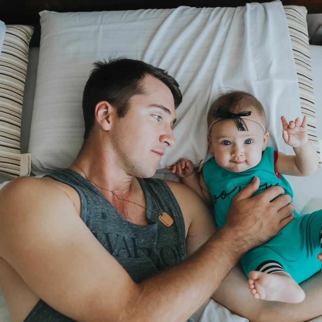 Dad and baby lying down on Classic organic foam pillows
