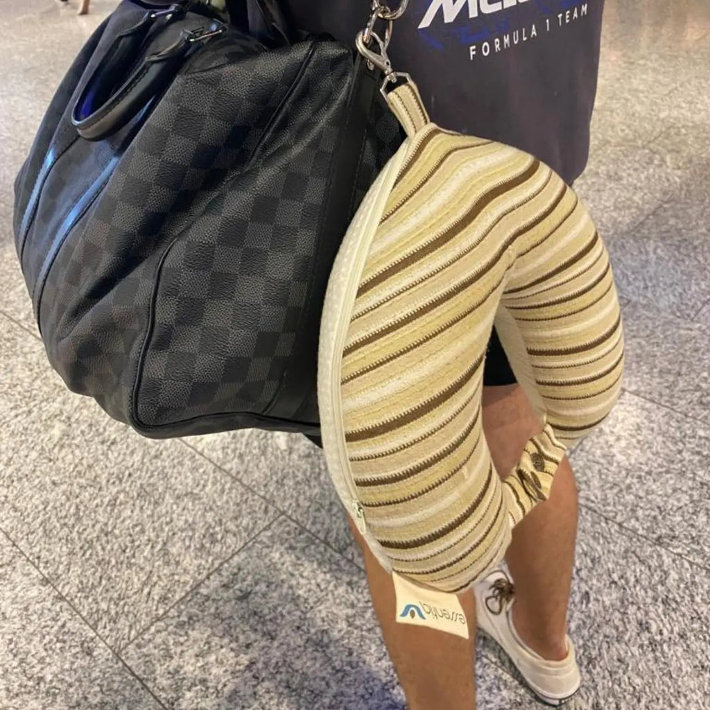 Essentia organic latex travel pillow shown clipped to a carry on bag